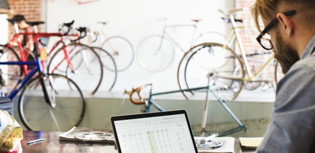 Profissional trabalhando com notebook em loja de bicicletas