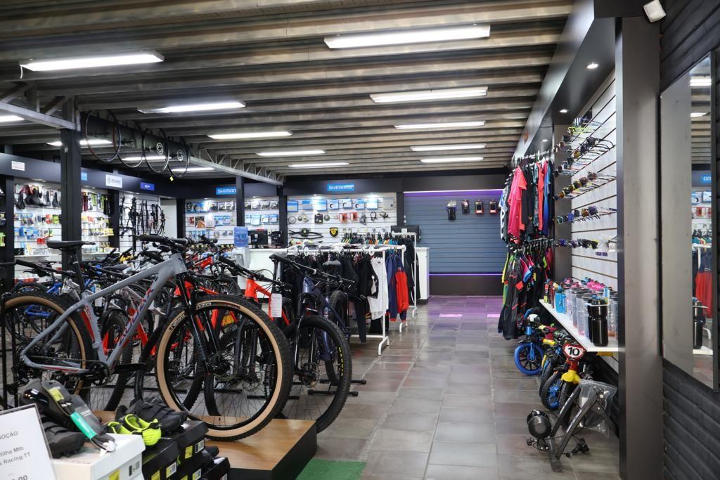 Interior de loja de bicicletas com acessórios e bicicletas expostas